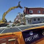 AN EXCAVATOR demolishes a building during an official groundbreaking in Taunton,, where the Mashpee Wampanoag tribe was to build the First Light Resort & Casino. The project was halted shortly afterward when a group of residents sued, arguing the federal government couldn't take the land into trust for the tribe. / AP FILE PHOTO/ELISE AMENDOLA