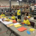 IVORY ELLA LLC employees, from left, Claritza Gonzales, Yasmin Ramos, Nelson Vasquez and Annette LaPietra, help build activity kits for national nonprofit Project Sunshine, which will be distributed to pediatric patients currently hospitalized. / COURTESY IVORY ELLA LLC