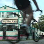 STAYING SAFE: A new PBN survey found many Rhode Islanders won’t feel safe around large groups of people until next year. For businesses that rely on tourism, that might mean a renewed focus on family activities this summer, including bike tours. Above, a cyclist passes Your Bike Shop in Warren. / PBN FILE PHOTO/RYAN T. CONATY