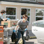 LOADING UP: Ric Wild, executive director at the Good Neighbors Inc. food pantry in East Providence, loads bags of food into a vehicle while volunteer Elaine Fredrick fills boxes. / PBN PHOTO/TRACY JENKINS