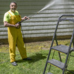 ONE-MAN GAME: David Rothenberg, owner of A Plus Handyman Services LLC, power-washes a house. The one-man operation offers a range of services, including painting, siding, excavating and sheet-rock installations. / PBN PHOTO/MICHAEL SALERNO