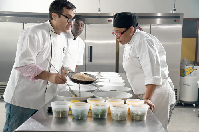 NOT CONVINCED: Joshua Riazi, left, manager at Genesis Center, leads a culinary class in February. Riazi isn’t sold on the idea of forming an association to serve as a “chamber of commerce” for the Rhode Island nonprofit sector.  / PBN PHOTO/MIKE SKORSKI