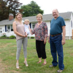 NEW HOME: Nicole Tickner with her daughter Lily, and parents George and Judy Vit. They are in front of the South Kingstown house that Tickner bought for them after they moved to Rhode Island to be closer to their granddaughter. / PBN PHOTO/ELIZABETH GRAHAM