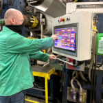 DOING HIS DUTY: Bill Burton, extruder team lead and U.S. Army veteran, operates an extrusion line on the Cooley manufacturing floor using a recently installed proprietary touch-screen technology. / COURTESY COOLEY GROUP