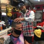 VICTOR CURET (right), owner of Gentleman's Quarters Barbershop, is offering free haircuts to people experiencing financial hardship. / COURTESY VICTOR CURET