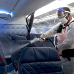 HEAVY DUTY: Melaku Gebermariam uses an electrostatic sprayer to disinfect the inside of a Delta Airlines jet between flights on July 22, at the Ronald Reagan Washington National Airport in Arlington, Va. / AP FILE PHOTO/NATHAN ELLGREN