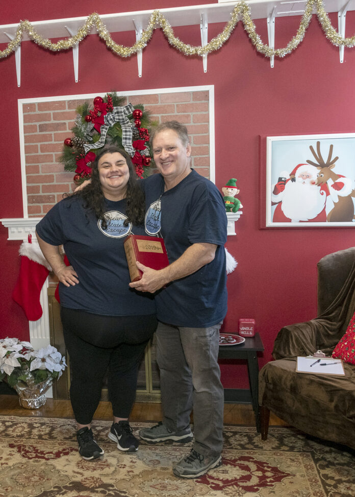 PUZZLE PIECES: Ocean State Escape owner Leonard Albanese, with daughter Rachel. They are in their Christmas-themed escape room in Johnston. / PBN PHOTO/MICHAEL SALERNO