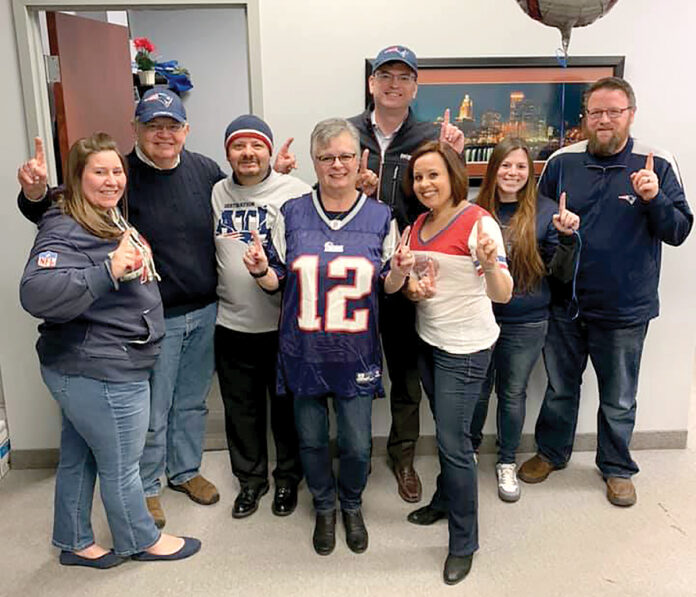 FOOTBALL FEVER: Secure Future Tech Solutions employees wear New England Patriots attire as part of a recent Patriots Spirit Day at the office.  COURTESY SECURE FUTURE TECH SOLUTIONS