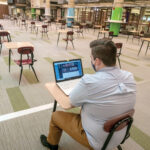 PLENTY OF ROOM: Tucker Quinn, a political science major from Warwick, studies alone at the Community College of Rhode Island in Warwick recently. Not many students are attending in-person classes in the fall semester. / PBN PHOTO/MICHAEL SALERNO