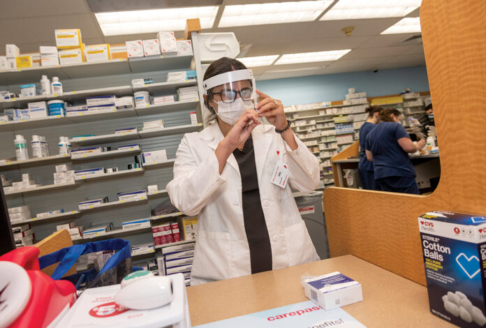 AT THE READY: Julia Tiberi, CVS pharmacy manager in Cumberland, prepares a dose of the flu vaccine. / PBN PHOTO/MICHAEL SALERNO