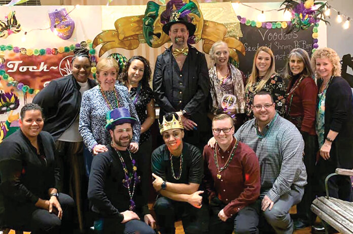 PICTURE PERFECT: Tockwotton on the Waterfront employees pose during a recent company Mardi Gras office party. COURTESY TOCKWOTTON ON THE WATERFRONT