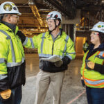 SITE MANAGEMENT: Gilbane Inc. CEO Michael McKelvy, center, speaks with Dauris Nunez, left, and Nury Ruiz during construction of the Twin River Tiverton Casino Hotel. / COURTESY GILBANE INC.