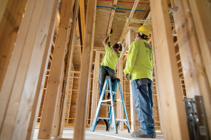 COMING TOGETHER: Construction workers Louiz Jandielson, left, and Vitor Dos Santos work on a home that is being put together by SWAP Inc. / PBN PHOTO/RUPERT WHITELEY