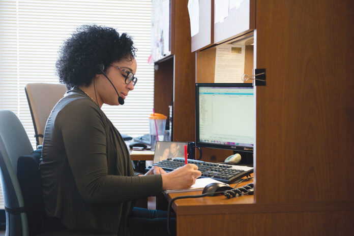 ON THE LINE: United Way of Rhode Island Call Center Manager Evelyn Cabrera takes a call at the organization’s office in Providence.  / COURTESY UNITED WAY OF RHODE ISLAND