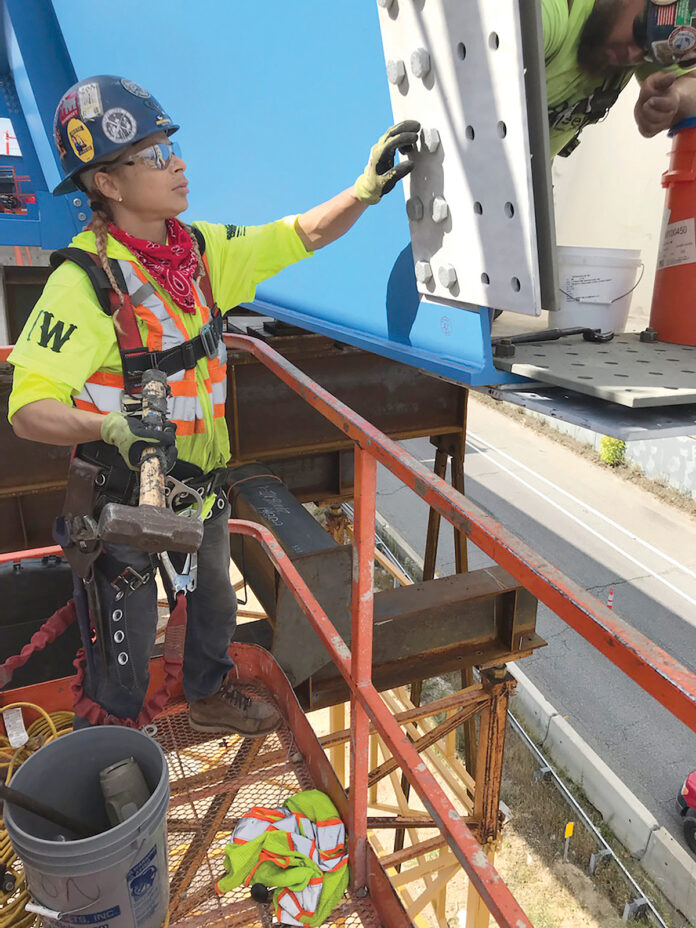 PIECING IT TOGETHER: Aetna Bridge Co. ironworker Lisa Silvio helps install bolts on a bridge under construction above the Route 6-10 connector in Providence.  / COURTESY LISA SILVIO