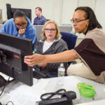 PROBLEM-SOLVING: Amica Mutual Insurance Co. employees, from left, Kimberly Meriweather, Keila Bianco and Esther Garcia work together at a computer station at the company’s Lincoln office. COURTESY AMICA MUTUAL INSURANCE CO.