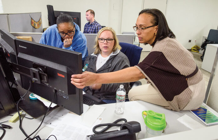 PROBLEM-SOLVING: Amica Mutual Insurance Co. employees, from left, Kimberly Meriweather, Keila Bianco and Esther Garcia work together at a computer station at the company’s Lincoln office. COURTESY AMICA MUTUAL INSURANCE CO.