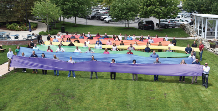 SUPPORTING INCLUSION: Cox Communications Inc. employees hold colored cloth to support the gay, lesbian, bisexual and transgender community. COURTESY COX COMMUNICATIONS INC.