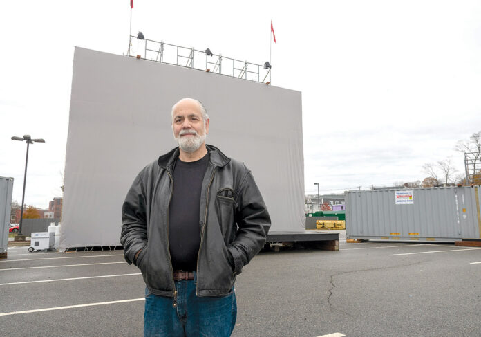 FIGHTING ON: Barnaby Evans, founder and executive artistic director of ­WaterFire Providence, says the nonprofit will survive the pandemic. He’s pictured in front of a stage erected in a parking lot for an outdoor play.  / PBN PHOTO/MICHAEL SALERNO