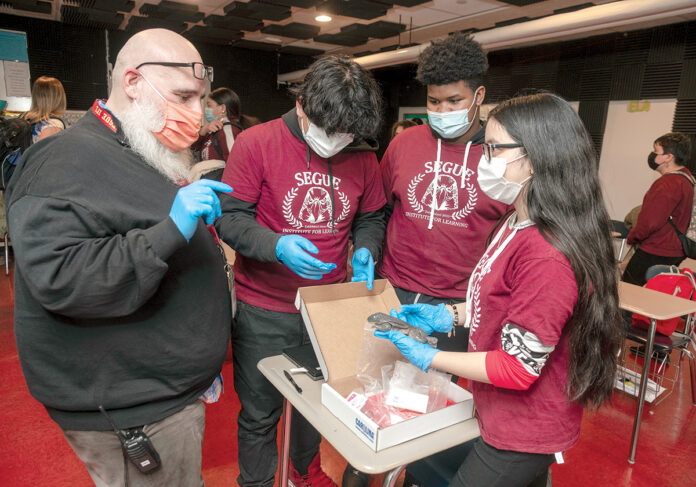 HELPING STUDENTS: Angelo Garcia, founder and head of school at Segue Institute for Learning in Central Falls, with eighth graders, from left: Marvin Gonzalez, Christian Beaton and Kimberly Ortega. / PBN PHOTO/MICHAEL SALERNO