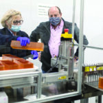 ALWAYS IMPROVING: Bradford Soap Works Inc. machine operator Paula Panizza holds a bar of soap while CEO and President Stuart Benton looks on. Benton says he tries to get everyone to focus on incremental improvement every day. / PBN PHOTO/RUPERT WHITELEY
