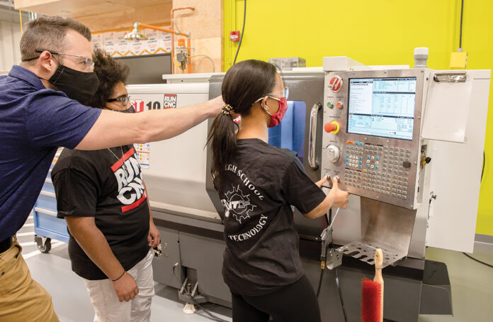 IN-CLASS INSTRUCTION: Briar Dacier, machine technology instructor at William M. Davies Jr. Career & Technical High School in Lincoln, with students Angel DeLaCruz and Mariama Barry in the machine lab. / PBN PHOTO/TRACY JENKINS