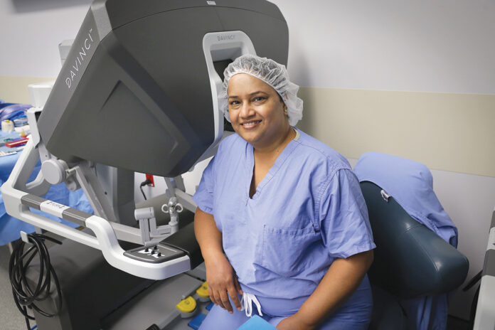 TECH SUPPORT: Dr. Subhashini Ayloo sits with the da Vinci surgery system that helps her perform complex liver surgery. Ayloo joined Brown Surgical Associates in February. / COURTESY LIFESPAN CORP./BILL MURPHY