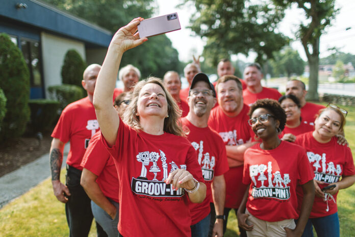PICTURE PERFECT: Groov-Pin Corp.’s Susan Smith, executive assistant and manager of human resources, takes a group selfie with her fellow employees at the company's Smithfield facility. / PBN PHOTO/RUPERT WHITELEY