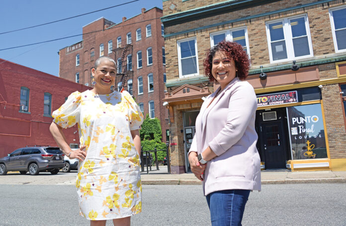 LINGUISTS: Be Moore Interpreting LLC co-founders and owners Zoila Bernal, left, and Shirley Moore stand outside of their office in Pawtucket. Moore, who often accompanied her parents and other adults on their visits to doctors, insurance companies and government offices to act as an interpreter, said the business was started to provide adult interpreters and translators so children wouldn’t have to take on that responsibility. / PBN PHOTO/ELIZABETH GRAHAM