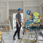 PLENTY OF PROJECTS: Jonathan Yaghjian, left, project manager, and Kurtis Quinn, a carpenter apprentice with Cranston-based Pariseault Builders Inc., work on the Zeta Tau Alpha Sorority House on the University of Rhode Island campus in South Kingstown. While many businesses were forced to close their doors  for much of 2020 due to the COVID-19 pandemic, Pariseault continued to work on a number of multimillion-dollar projects. / PBN PHOTO/ELIZABETH GRAHAM