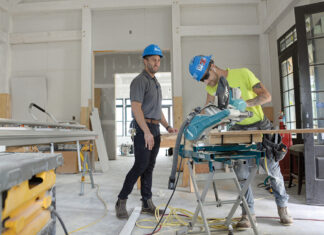 PLENTY OF PROJECTS: Jonathan Yaghjian, left, project manager, and Kurtis Quinn, a carpenter apprentice with Cranston-based Pariseault Builders Inc., work on the Zeta Tau Alpha Sorority House on the University of Rhode Island campus in South Kingstown. While many businesses were forced to close their doors  for much of 2020 due to the COVID-19 pandemic, Pariseault continued to work on a number of multimillion-dollar projects. / PBN PHOTO/ELIZABETH GRAHAM