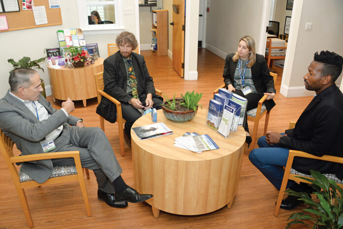 TABLE TALK: AdCare Rhode Island Inc. CEO Fred A. Trapassi Jr., left, meets with staff members at AdCare’s North Kingstown facility. With Trapassi are, from left, Dr. Michael Coburn, medical director; Sarah Horgan, chief operating officer; and Courtney Stafford, director of clinical process improvement. / PBN PHOTO/ELIZABETH GRAHAM