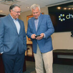 AFFORDABLE ACCESS: Blaine Carroll, right, president of First Circle Inc., shows Joseph Perroni, CEO of Delta Dental of Rhode Island, the Chewsi app, which was launched in 2017 by First Circle, a subsidiary of Delta Dental. / PBN PHOTO/ELIZABETH GRAHAM