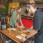 PREPPING FOR DINERS: Natasha Nichols, left, vice president of Chow Fun Inc., helps manager Antonio Galvao set up tables in Chow Fun’s new restaurant OZ Tacos & Tequila in Lincoln.  / PBN FILE PHOTO/MICHAEL SALERNO