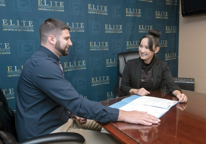 TITLE TALK: Diep Nguyen, right, managing member of Elite Title & Closing Services LLC in East Providence, meets with Robert Watson, associate ­attorney. / PBN PHOTO/MICHAEL SALERNO