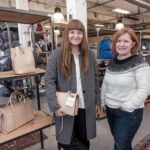 FASHION ON DISPLAY: Leather bags and suitcases surround former Lotuff Leather executives Lindy McDonough, left, and Ellen McNulty-Brown in this photo taken in 2016. / PBN FILE PHOTO/MICHAEL SALERNO