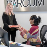 STAYING COMMITTED: Despite challenges within the employment market, Marcum LLP leadership has remained dedicated to addressing issues surrounding diversity and inclusion at the accounting firm. Partner Erica Olobri, left, and receptionist Erin Oates are part of the staff at Marcum’s Providence office.  PBN PHOTO/TRACY JENKINS