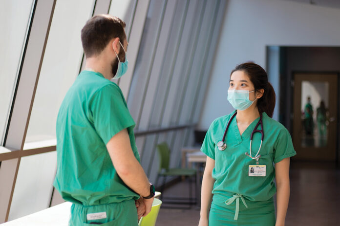 TRAINING DAYS: Brown University medical students Anthony Formicola, left, and Thi My Linh Tran talk while on duty on the labor and delivery floor at Care New England Health System’s Women & Infants Hospital in Providence.  / COURTESY CARE NEW ENGLAND HEALTH SYSTEM/RYAN PICKERING