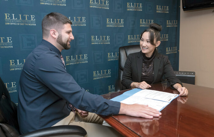 TITLE TALK: Diep Nguyen, right, managing member of Elite Title & Closing Services LLC in East Providence, meets with Robert Watson, associate ­attorney. / PBN FILE PHOTO/MICHAEL SALERNO