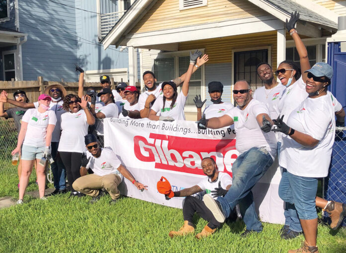 TEAMWORK: Gilbane Building Co. employees partner with nonprofit Rebuilding Together on a community service project. / COURTESY GILBANE BUILDING CO.
