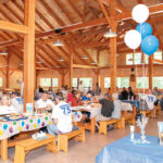 DIAMOND JUBILEE: Pariseault Builders Inc. employees have lunch at the company’s 75th anniversary event at Camp Yawgoog in Hopkinton. / COURTESY PARISEAULT BUILDERS INC.