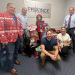FEELING FESTIVE: The Province Mortgage Associates Inc. team poses near gift bags to be delivered as part of the company’s “Smiles to Seniors” holiday initiative. / COURTESY PROVINCE MORTGAGE ASSOCIATES INC.