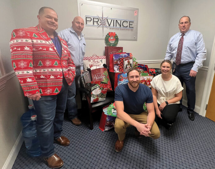FEELING FESTIVE: The Province Mortgage Associates Inc. team poses near gift bags to be delivered as part of the company’s “Smiles to Seniors” holiday initiative. / COURTESY PROVINCE MORTGAGE ASSOCIATES INC.