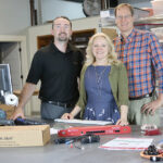 STAYING ALERT: AVTECH Software Inc. employees Rick Grundy, Anne Sigourney and Michael Sigourney pose with the company’s Room Alert ­environment monitor. / COURTESY AVTECH SOFTWARE INC.
