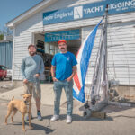 SMALL-CRAFT SPECIALISTS: New England Yacht Rigging Inc. President Kyle Wishart, left, and Vice President Daniel Martinez outside their Warwick shop with shop mascot Hooper.  PBN PHOTO/MICHAEL SALERNO