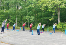 LIMBERING UP: Employees at Groov-Pin Corp. in Smithfield stretch before an outdoor yoga session, one of several initiatives the company introduced that became popular and is now a monthly event. COURTESY GROOV-PIN CORP.