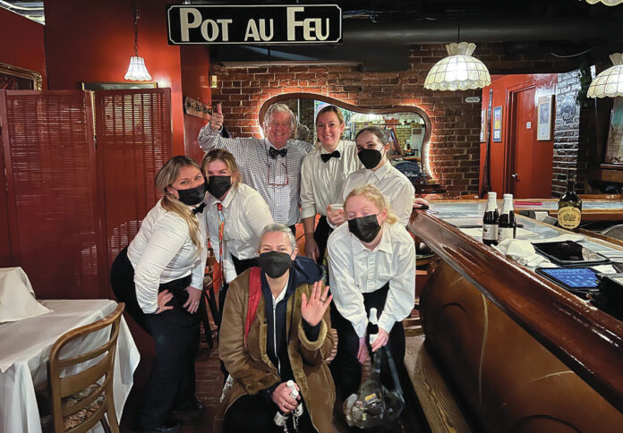 BOB BURKE, back row at left, owner of Pot au Feu Restaurant in Providence, says that while local restaurants are back to being full after the COVID-19 pandemic impacted operations, the costs for restaurants to operate has risen due to inflation and supply chain problems. / COURTESY POT AU FEU