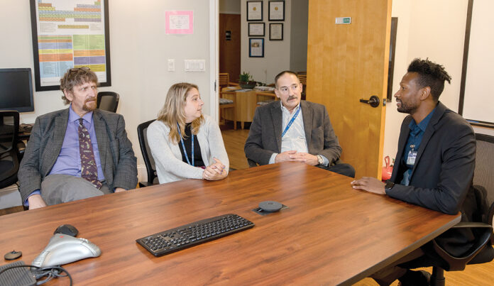 HEALTHY CONVERSATION: From left, Dr. Michael Coburn, medical director; Chief Operating Officer Sarah Horgan; Fred A. Trapassi Jr., CEO; and Courtney Stafford, director, clinical process improvement, at AdCare Rhode Island Inc. meet at the organization’s North Kingstown office. PBN PHOTO/TRACY JENKINS