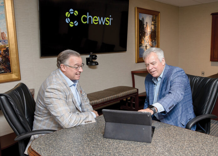 AVAILABLE OPTIONS: From left, First Circle Inc. CEO Joe Perroni and Blaine Carroll, president of First Circle and Chewsi RI, look over a tablet with the company’s new dentist search function.  PBN PHOTO/TRACY JENKINS