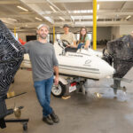QUIET RIDE: Flux Marine Ltd. engineers Milo Ferrazzolo, Attila Delingat, Linden Zlotea and Greg Roche pose with boats and motors in their new Bristol location.   PBN PHOTO/DAVID HANSEN